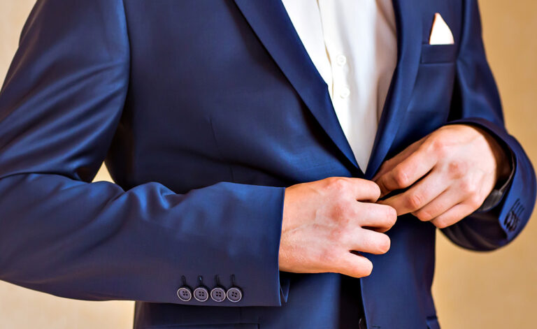 A young man buttoning a suit