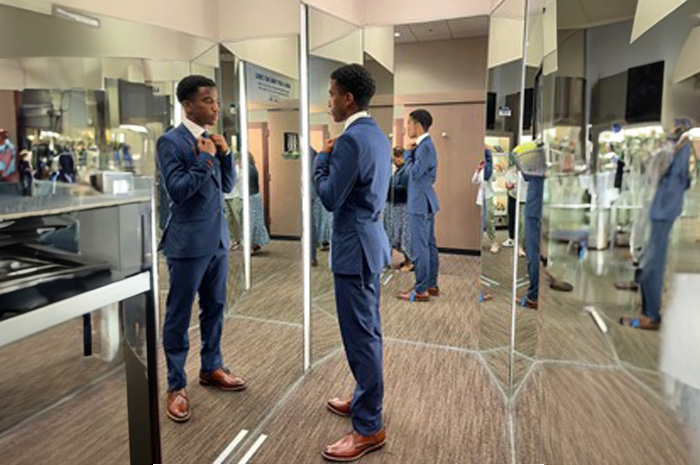 a young man is test fitting a suit
