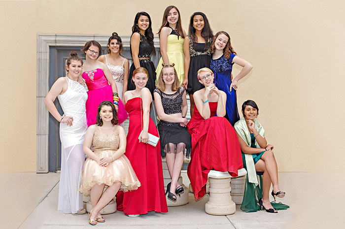 several teenaged girls in prom dresses posing together